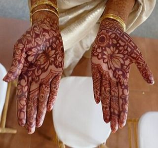 mani con decorazioni e tatuaggi temporanei all’hennè
